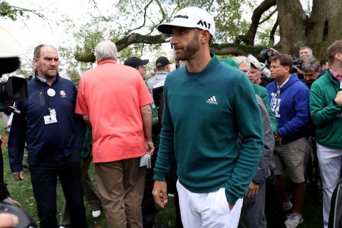 Down and out: Dustin Johnson heads for the clubhouse after declaring himself unfit to play at last year's Masters