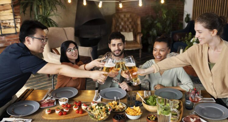 Diverse group of friends toasting glasses over a dinner table